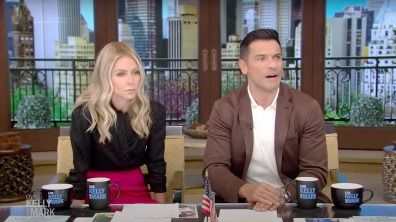 Kelly Ripa and Mark Consuelos staring at audience