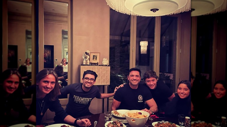 Mark Consuelos sitting at a table with his kids and a friend