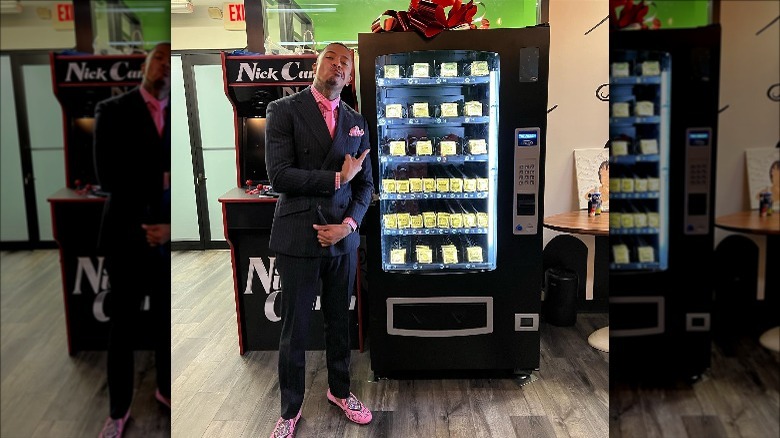 Nick Cannon standing in front of his condom vending machine