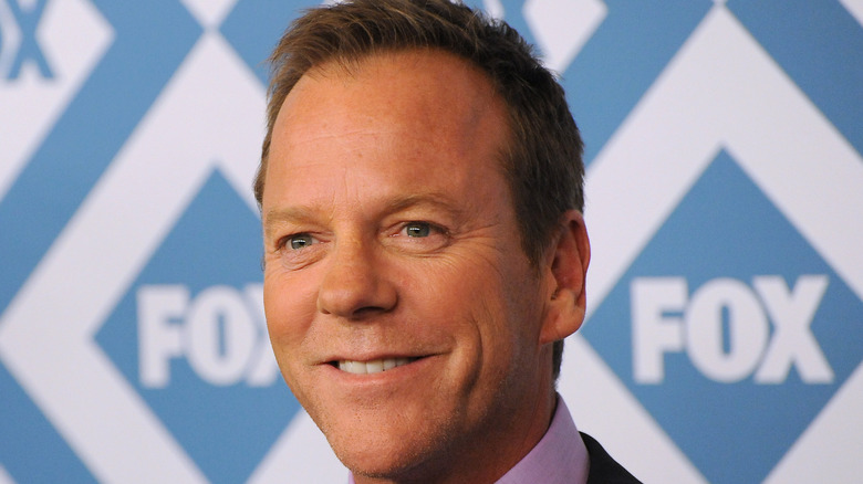 Kiefer Sutherland smiles at an event