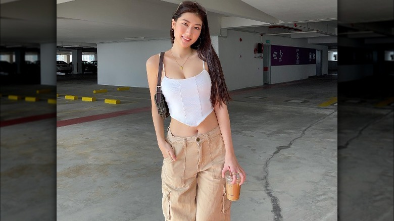 Woman in crop tank top and tan cargo pants