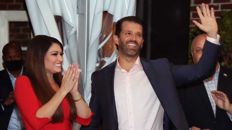 Kimberly Guilfoyle and Donald Trump Jr. smiling and waving