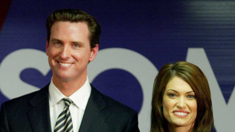 Gavin Newsom smiling next to Kimberly Guilfoyle