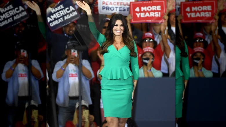 Kimberly Guilfoyle in green peplum dress waving arm