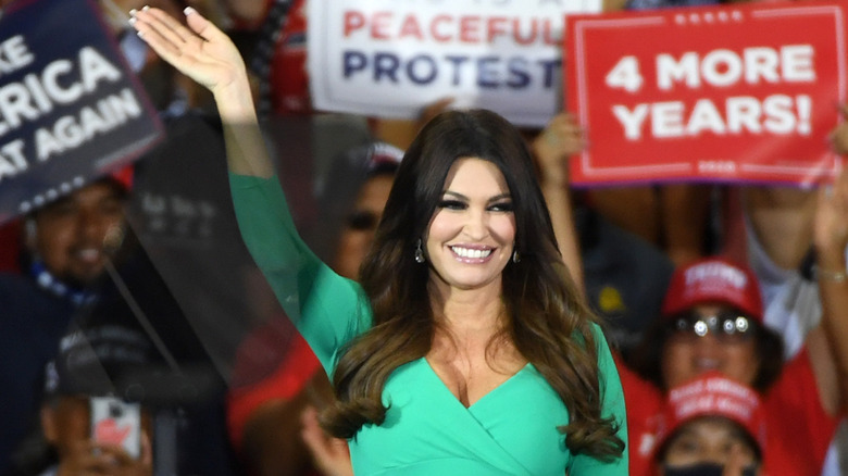 Kimberly Guilfoyle waves in a green dress