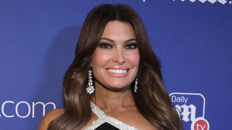 Kimberly Guilfoyle smiling in heavy makeup on red carpet