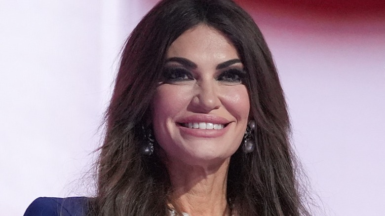 Kimberly Guilfoyle smiling on stage in unnatural makeup