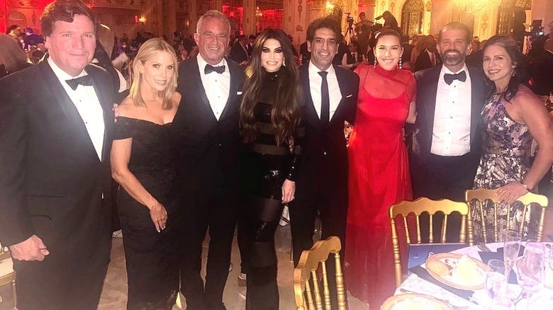 Tucker Carlson, Cheryl Hines, RFK Jr., Kimberly Guilfoyle, Omeed Malik, Caroline Malik, Donald Trump Jr., and Tulsi Gabbard posing