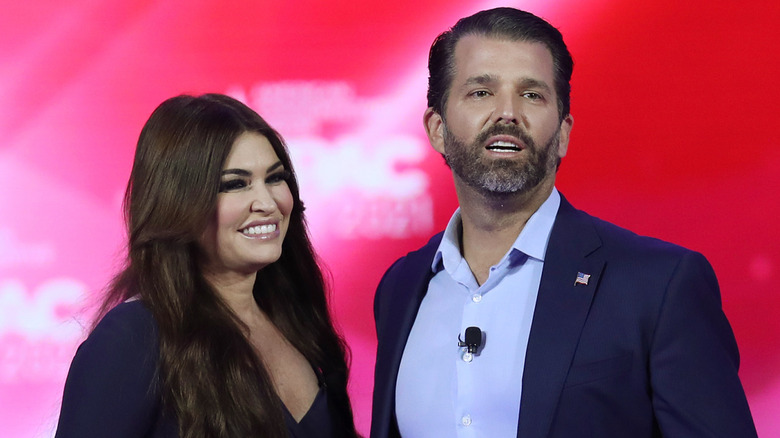 Kimberly Guilfoyle and Donald Trump Jr. stand next to each other on a stage