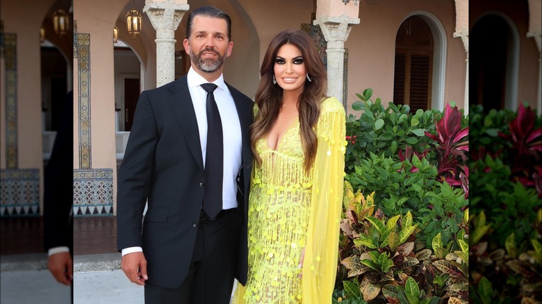 Donald Trump Jr. in suit standing next to airbrushed Kimberly Guilfoyle, both smiling