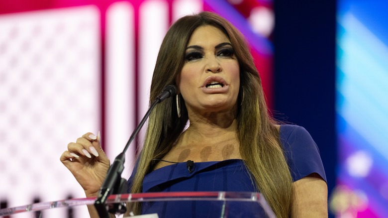 Kimberly Guilfoyle speaking at a podium, scowling