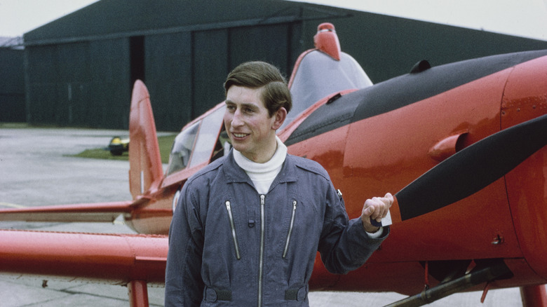 Prince Charles standing next to a plane