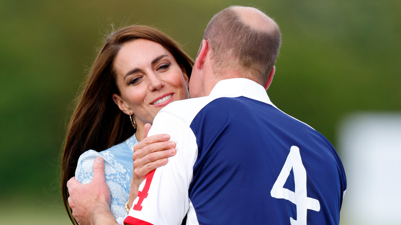 Prince William and Kate Middleton embrace on field