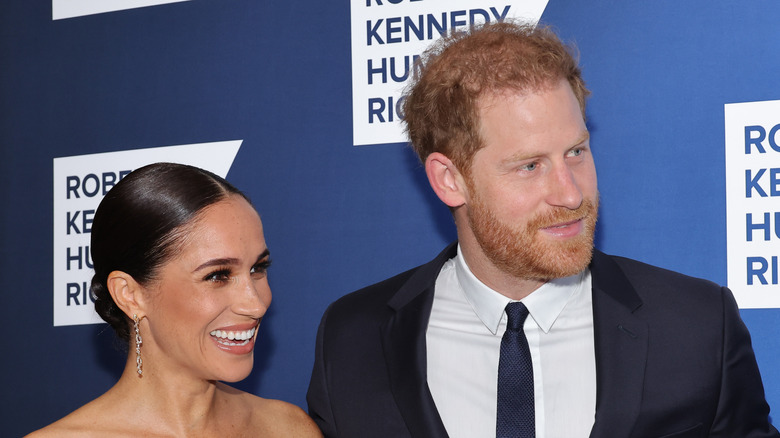 Prince Harry and Meghan Markle smiling at an event