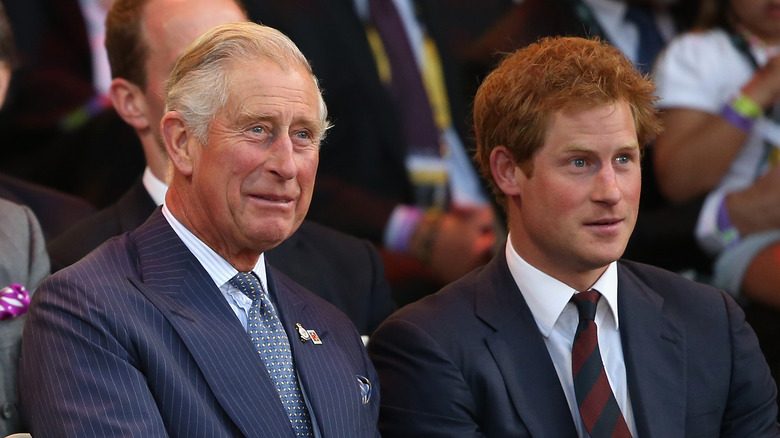 King Charles seated with Prince Harry