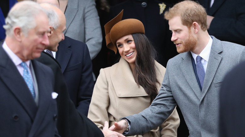 King Charles watches as Meghan Markle and Prince Harry chat