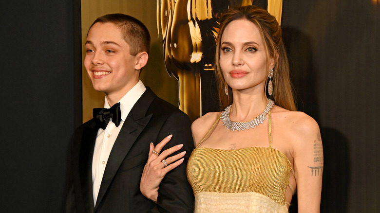 Knox Jolie-Pitt smiles alongside his mother Angelia Jolie at a red carpet event