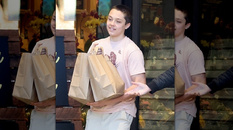 Knox Jolie-Pitt shaved head carrying groceries