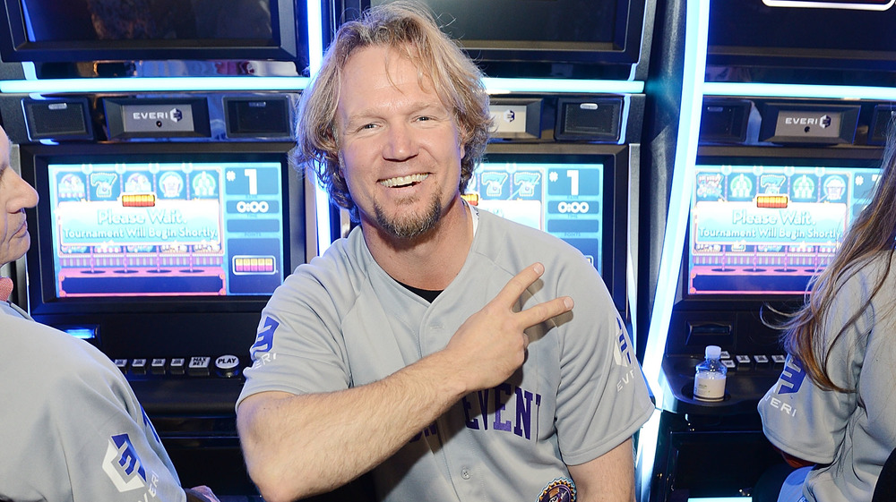 Kody Brown smiling in front of slot machine