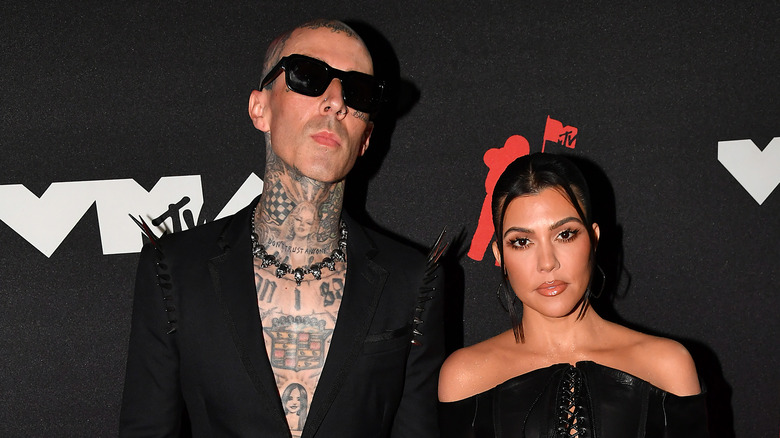 Travis Barker & Kourtney Kardashian posing 