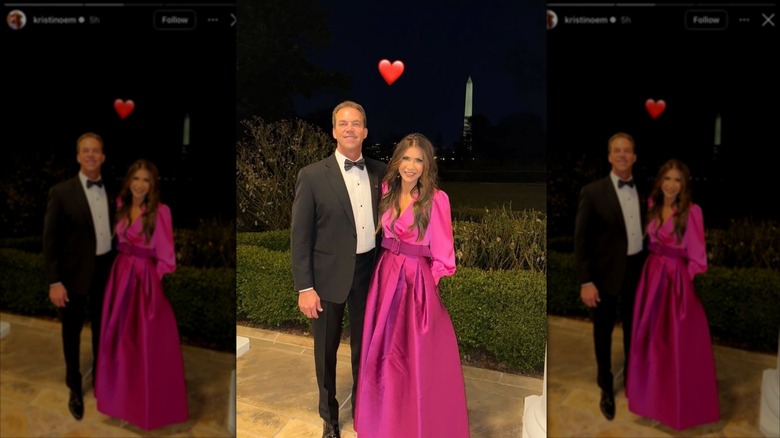 Kristi Noem wears a hot pink dress while standing next to husband Bryon Noem at the White House