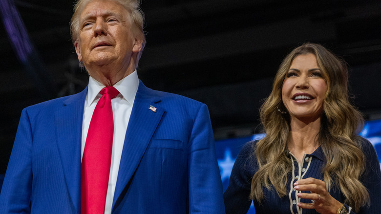 Donald Trump stands next to Kristi Noem