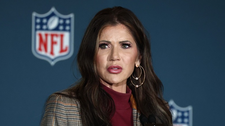 Kristi Noem scowling at a press conference for the 2025 Super Bowl