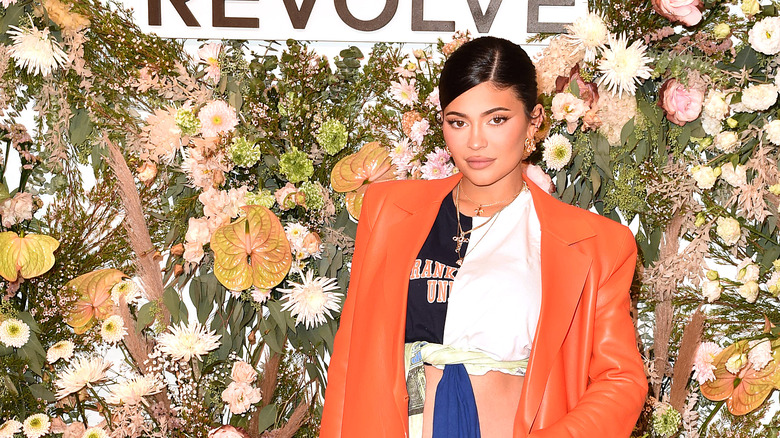 Kylie Jenner at Revolve event in orange coat