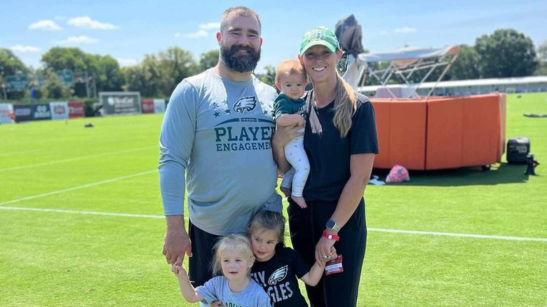 Jason Kelce, Kylie Kelce, and their three daughters posing at a game