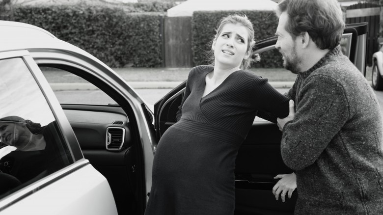 woman in labor getting in car