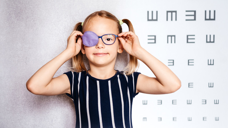 Child wearing glasses and eye patch