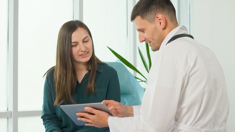 Woman and doctor look at tablet