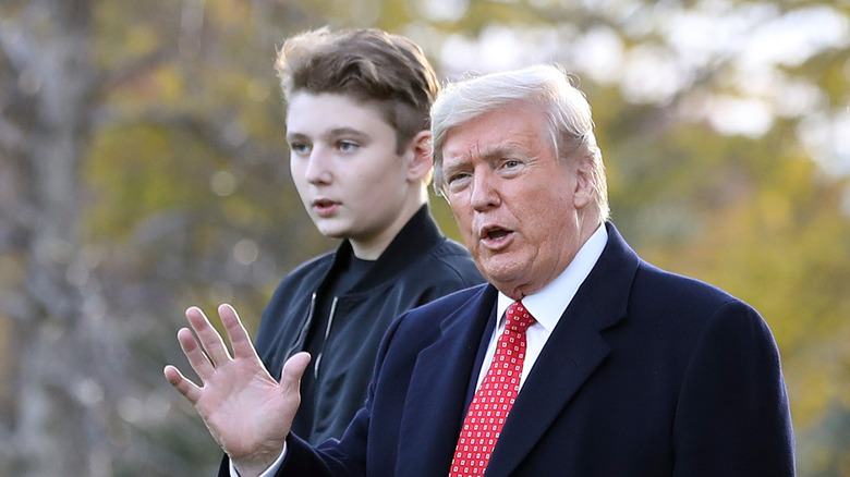 Donald Trump waving while walking next to his son Barron