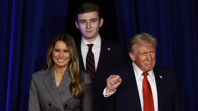 Barron standing on stage behind his parents, Melania and Donald Trump