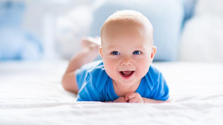 baby in blue onesie crawling