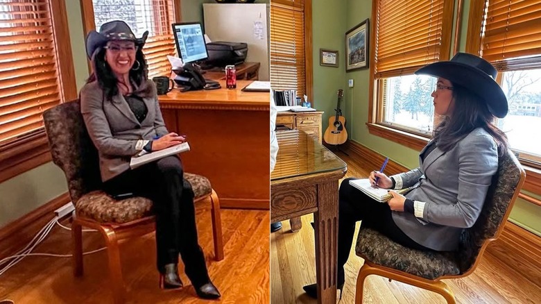 Lauren Boebert seated in a chair holding a notepad and pen and wearing a cowboy hat