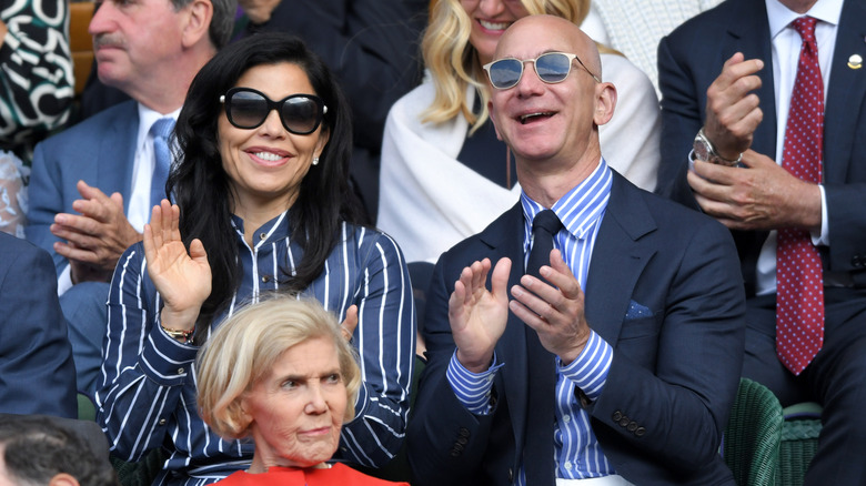 Lauren Sánchez and Jeff Bezos clapping at an event