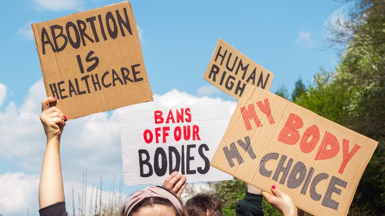 protestors holding signs at a rally