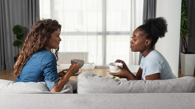 two women talking on sofa