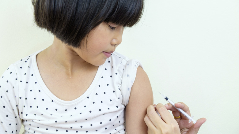 A young girl getting a shot