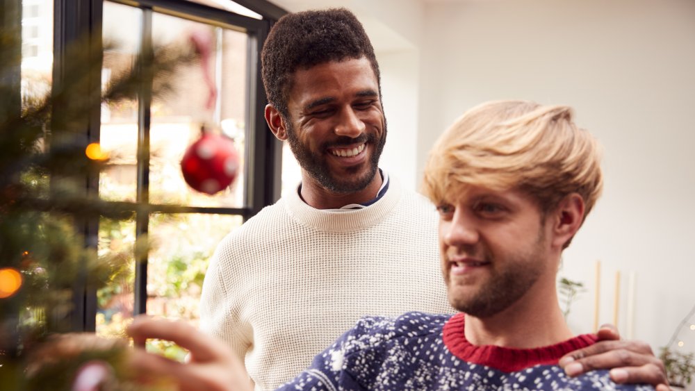 couple hanging christmas ornaments