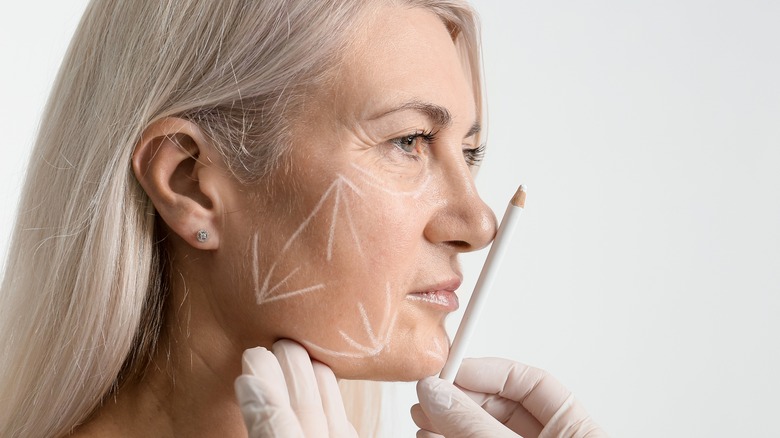 doctor pressing pencil to woman's face