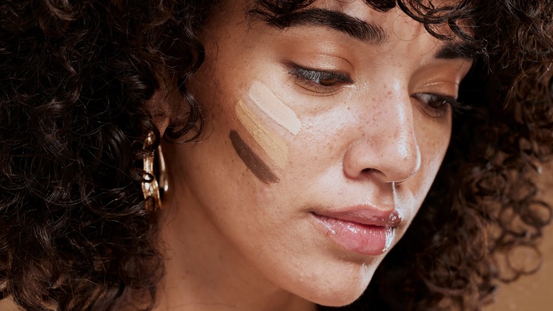 Woman considering three foundation shades