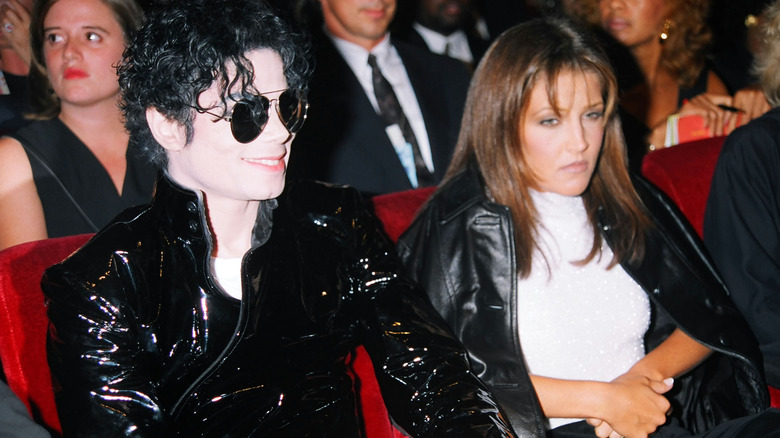 Michael Jackson and Lisa Marie Presley sitting at event