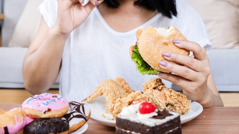 woman eating burger and wings