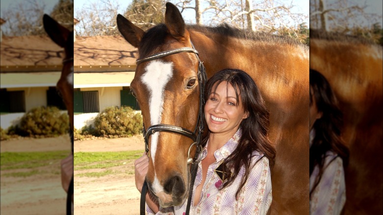 Shannen Doherty smiling with a horse