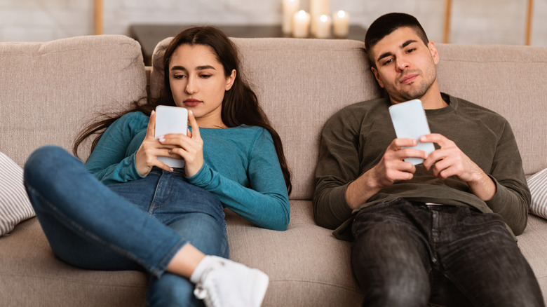 couple on the couch on their phones