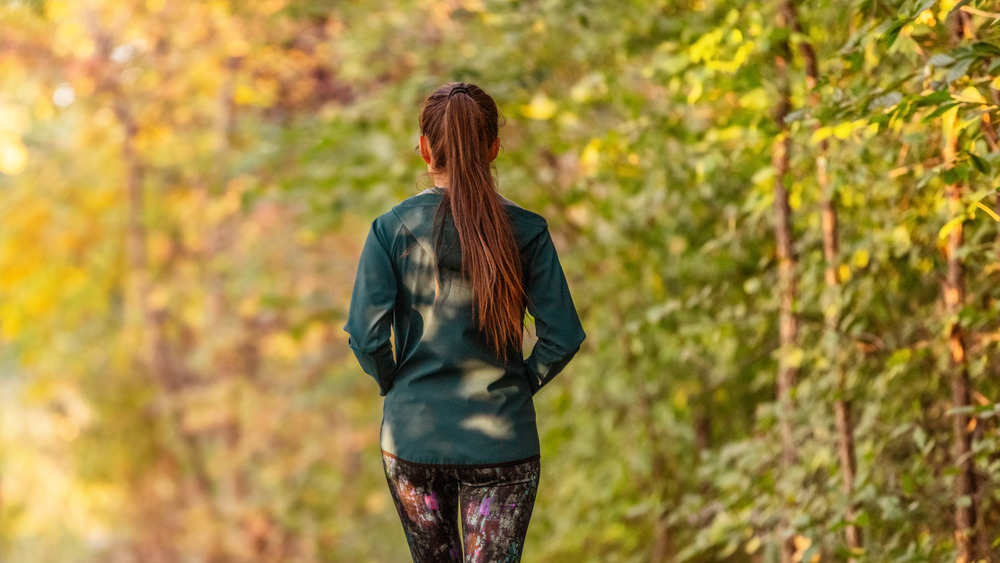 Woman walking in the woods in the fall