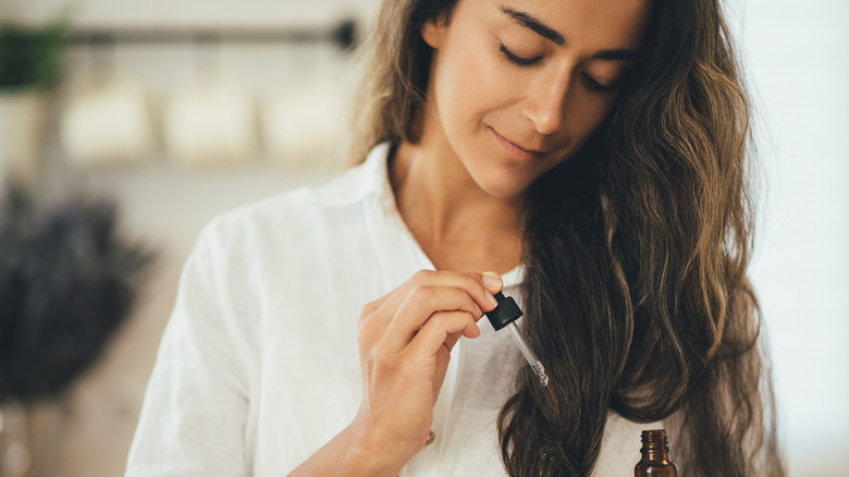 Woman applying hair serum