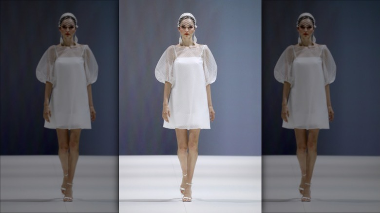 model walking runway in white dress